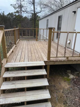 a view of balcony with wooden floor and fence