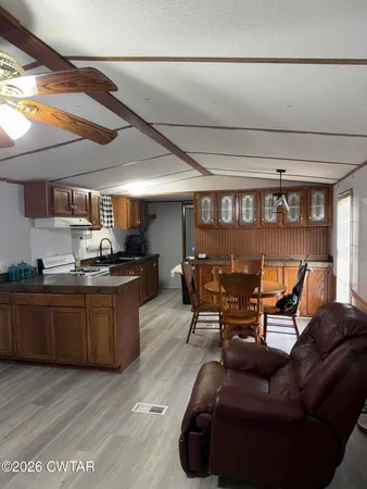 a living room with stainless steel appliances kitchen island granite countertop furniture and a large window