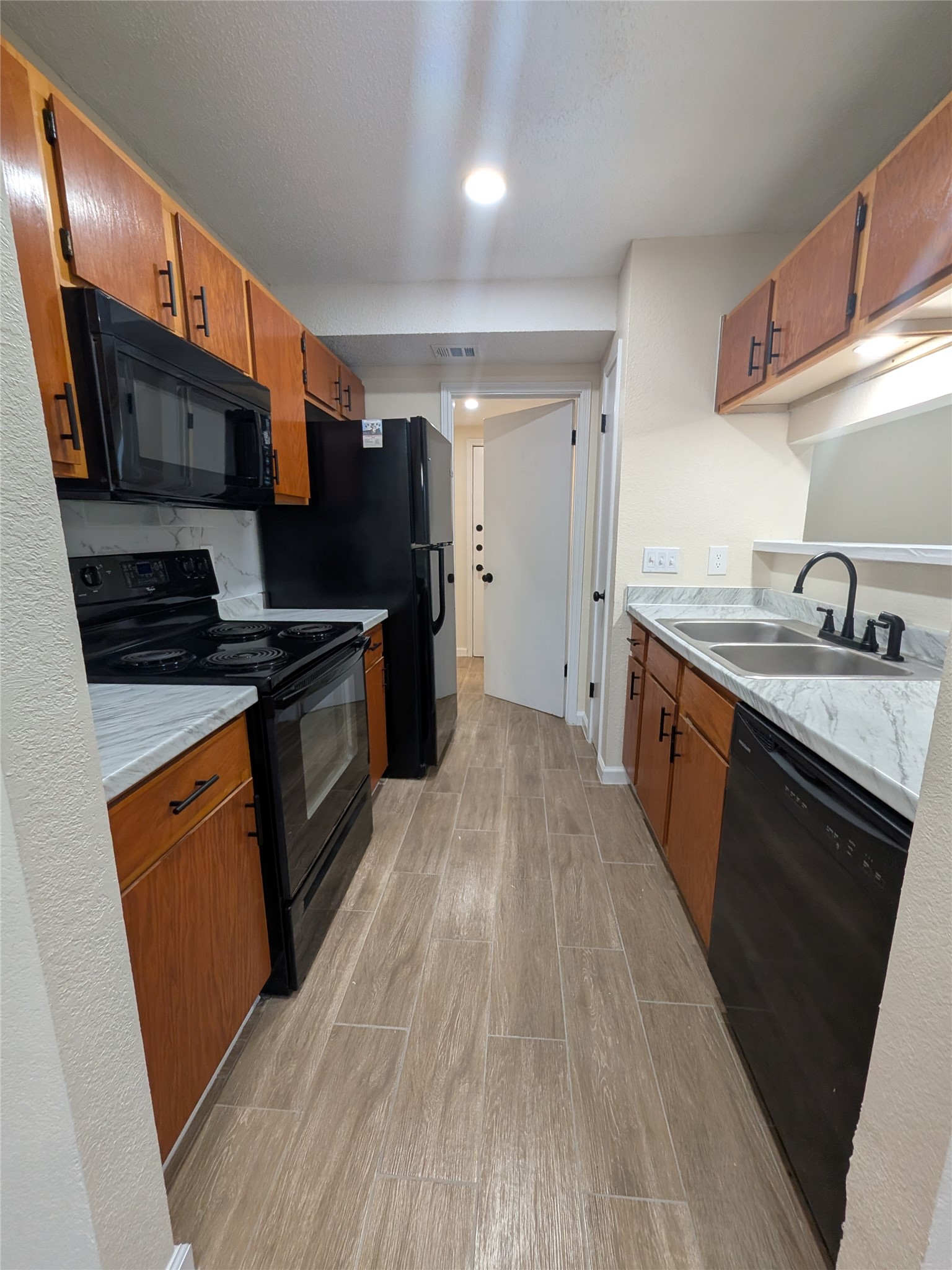 13303 Lyndhurst Street, Unit B Austin, TX 78729 - Photo 6 of 13 A well-appointed galley kitchen offers ample counter space and modern appliances for culinary endeavors.