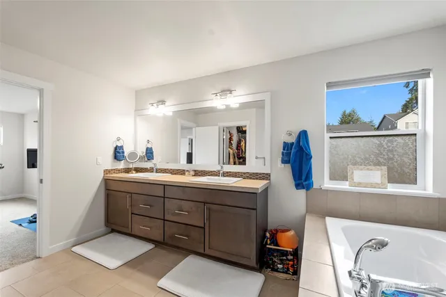 a bathroom with a tub sink and mirror