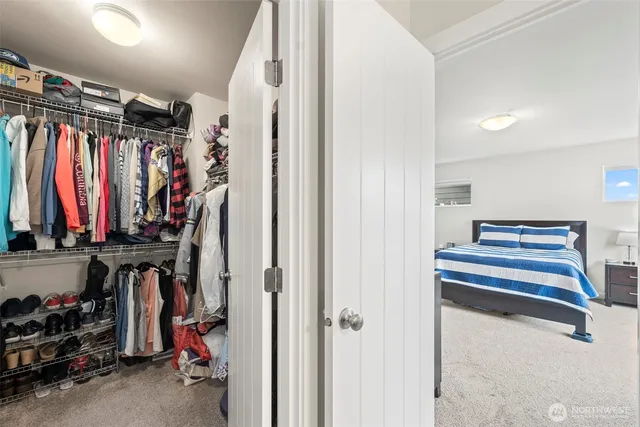 a view of walk in closet with clothes and shoes