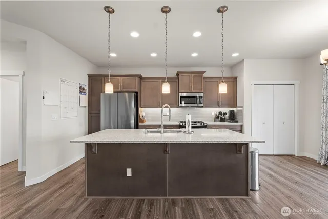 a kitchen with kitchen island a sink stainless steel appliances and cabinets