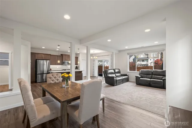 a living room with furniture a table and kitchen view