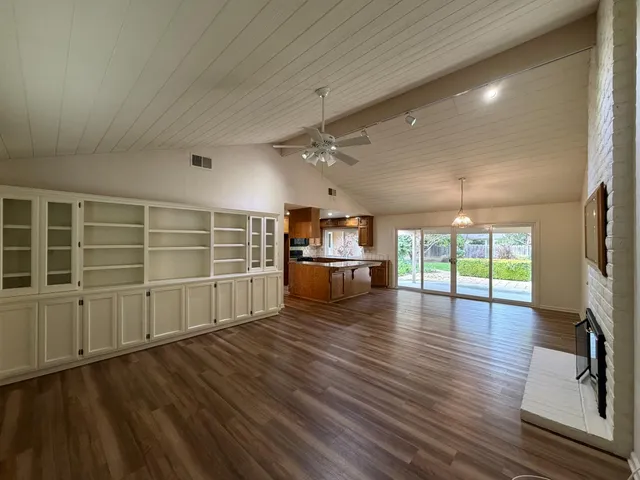 a large kitchen with kitchen island a large counter top and stainless steel appliances