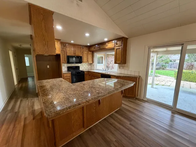 a kitchen with stainless steel appliances granite countertop a stove and a microwave