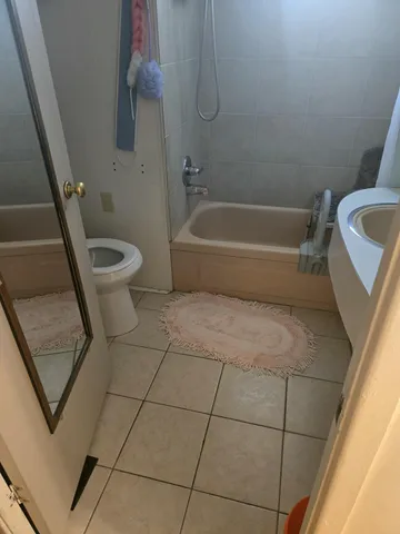 a bathroom with a granite countertop bathtub and toilet