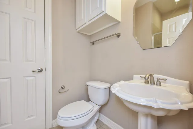 a bathroom with a toilet a sink and mirror