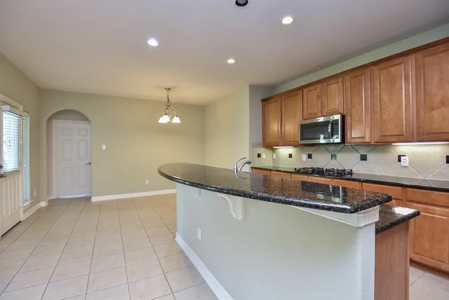 a kitchen with stainless steel appliances granite countertop a sink a stove a microwave and cabinets