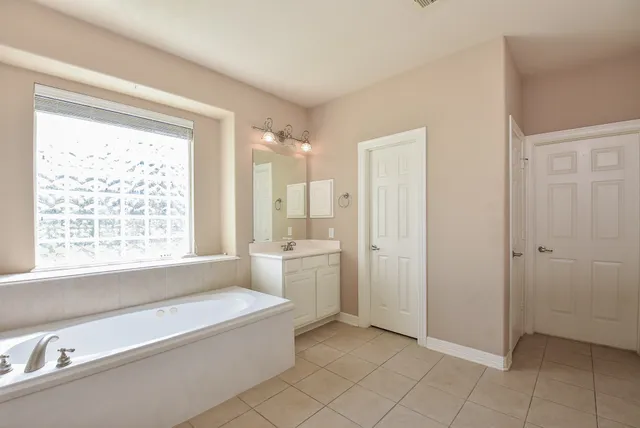 a spacious bathroom with a bathtub and a sink