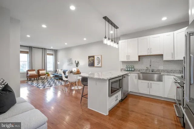 a kitchen with stainless steel appliances granite countertop a stove top oven a sink a counter space and cabinets