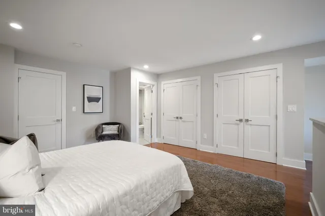 a spacious bedroom with a bed and a dresser