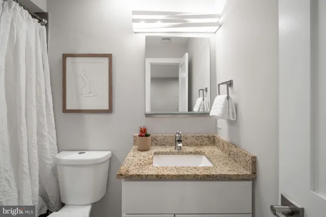 a bathroom with a granite countertop sink and a mirror
