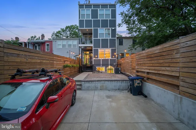 a backyard view of a house with basket ball court tables and chairs