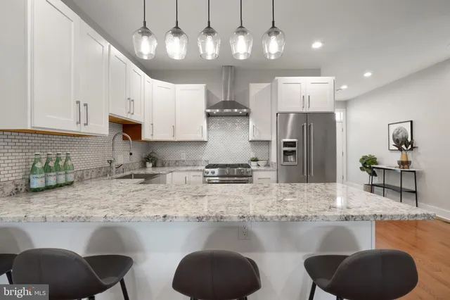 a kitchen with stainless steel appliances granite countertop a sink refrigerator stove and microwave