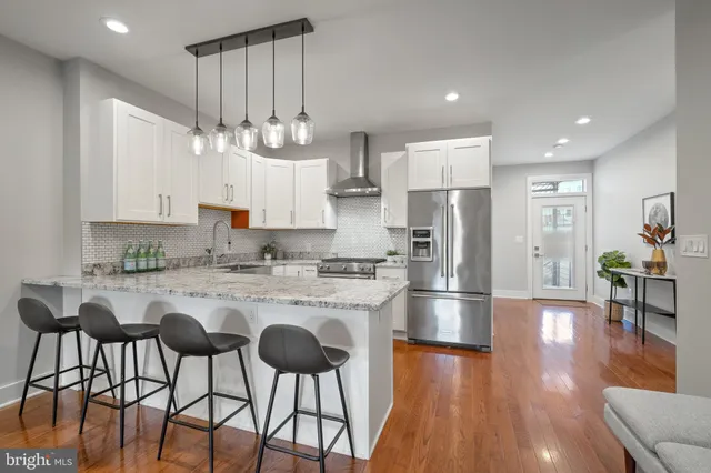 a kitchen with stainless steel appliances a dining table chairs microwave and cabinets