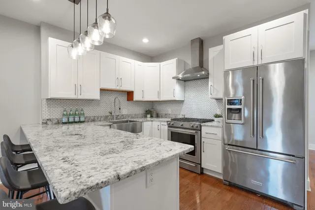 a kitchen with stainless steel appliances granite countertop a sink stove and refrigerator