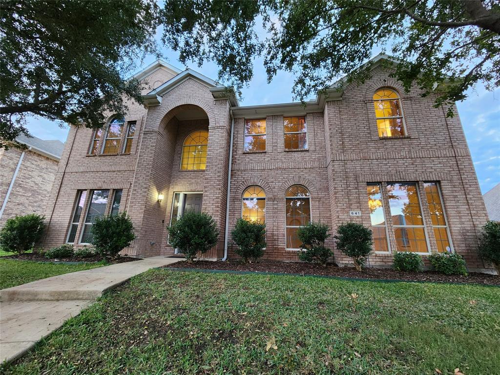 a front view of a house with yard and green space
