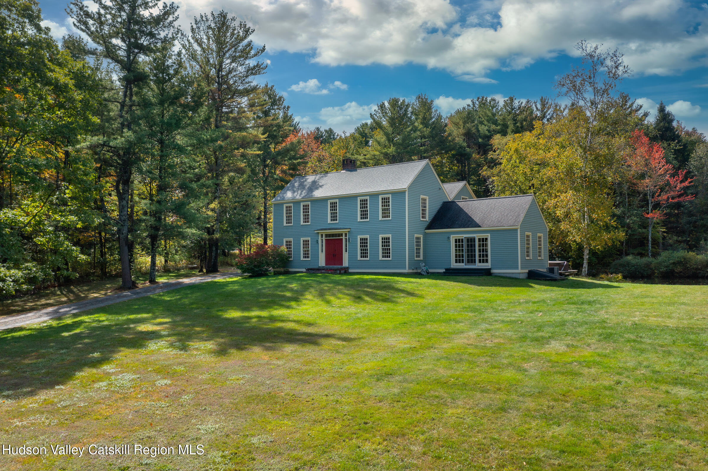 a view of a big house with a big yard and large trees