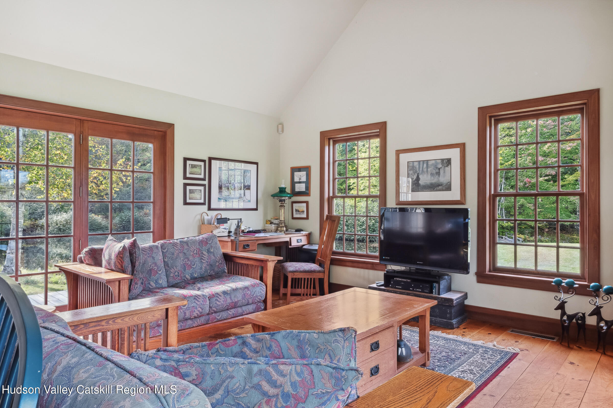 2205 County Rte 5 Canaan, NY 12029 - Photo 13 of 45 a living room with furniture a flat screen tv and a floor to ceiling window
