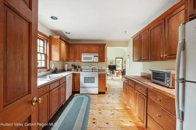 a kitchen with granite countertop wooden cabinets stainless steel appliances a sink and a window