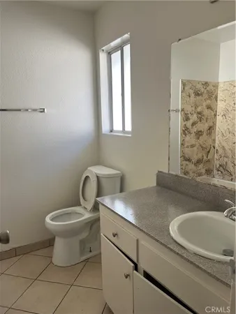 a view of an empty room with wooden floor and a ceiling fan
