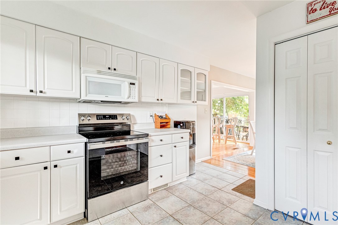 200 Pond Road Lancaster, VA 22503 - Photo 28 of 48 a kitchen with white cabinets and appliances