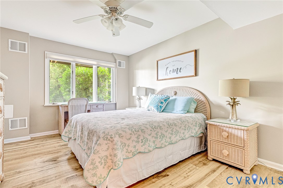 200 Pond Road Lancaster, VA 22503 - Photo 43 of 48 a bedroom with a large bed and a chandelier