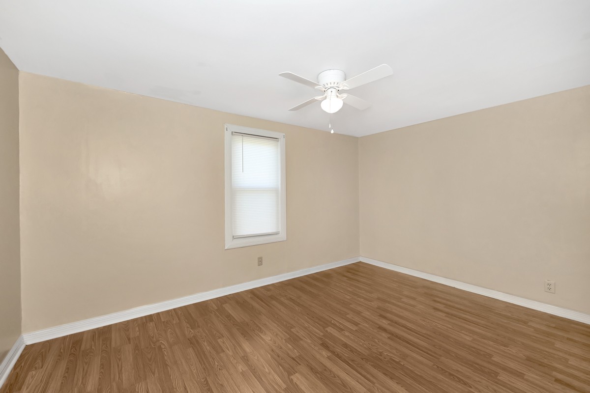 16871 New Cut Road Athens, AL 35614 - Photo 23 of 40 an empty room with wooden floor and fan