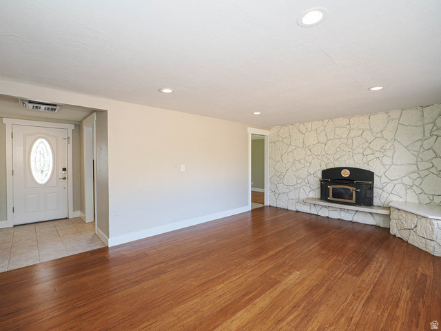 154 East 3000th Street South Bountiful, UT 84010 - Photo 10 of 37 Living area featuring wood-finish flooring, recessed lighting, and a stone accent wall with a built-in fireplace