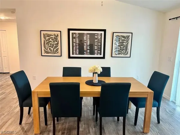 a kitchen with stainless steel appliances granite countertop a table chairs microwave and refrigerator