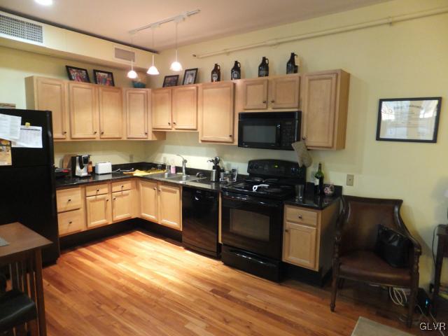 11 West 2nd Street, Unit 141 Bethlehem, PA 18015 - Photo 7 of 12 a kitchen with stainless steel appliances granite countertop a stove top oven a sink dishwasher and white cabinets with wooden floor