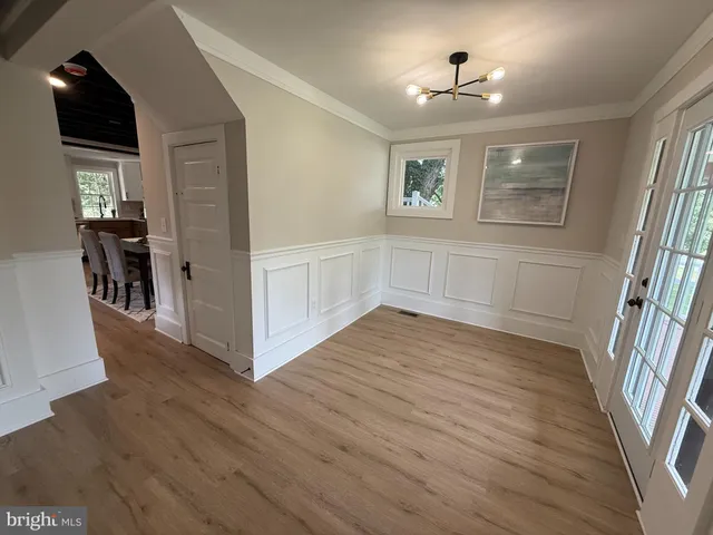 a view of empty room with wooden floor