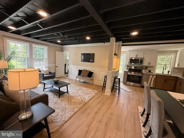 a living room with furniture and a view of kitchen