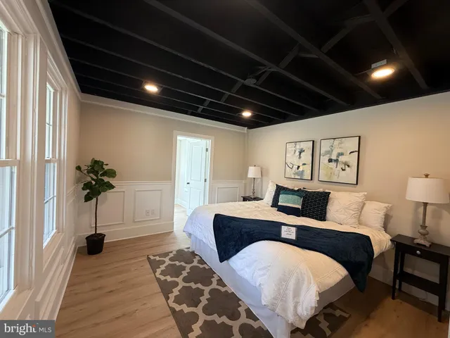 a spacious bedroom with a large bed and a potted plant