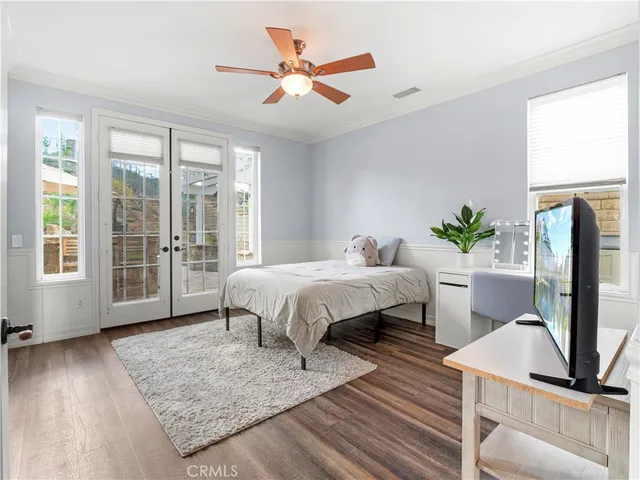 a spacious bedroom with a bed a couch and a large window