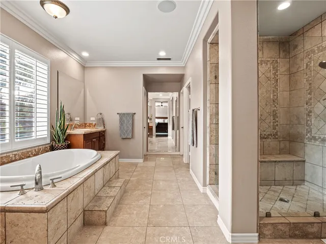 a large spacious bathroom with a double vanity sink a large mirror and a bathtub