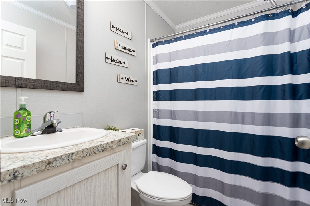 6610 Lear Nagle Road, Unit 286 North Ridgeville, OH 44039 - Photo 14 of 14 Bathroom with toilet, a shower with curtain, vanity, and ornamental molding