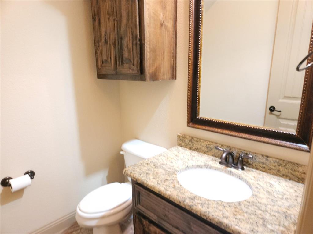 1208 Melcer Street Plano, TX 75074 - Photo 12 of 37 a bathroom with a granite countertop sink a mirror and a toilet