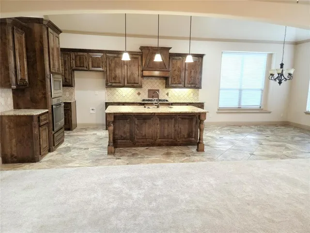 a view of a kitchen with stainless steel appliances granite countertop a stove and a refrigerator