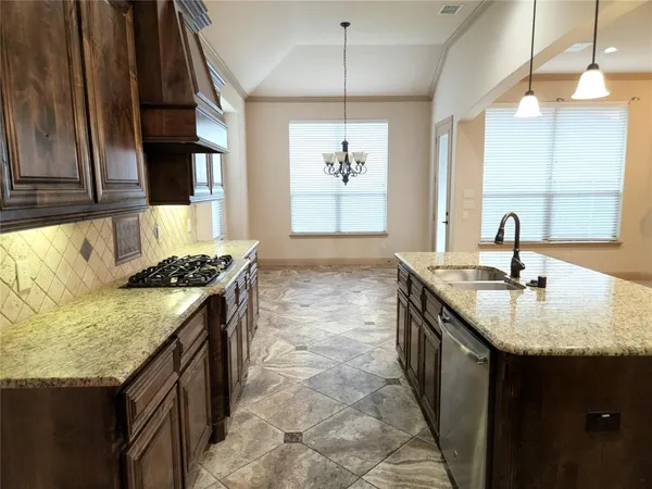 a kitchen with granite countertop a sink stove and cabinets