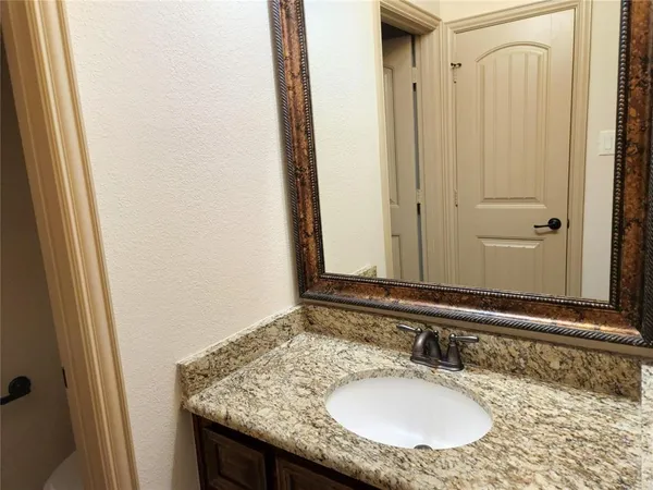 a bathroom with a granite countertop sink and a mirror