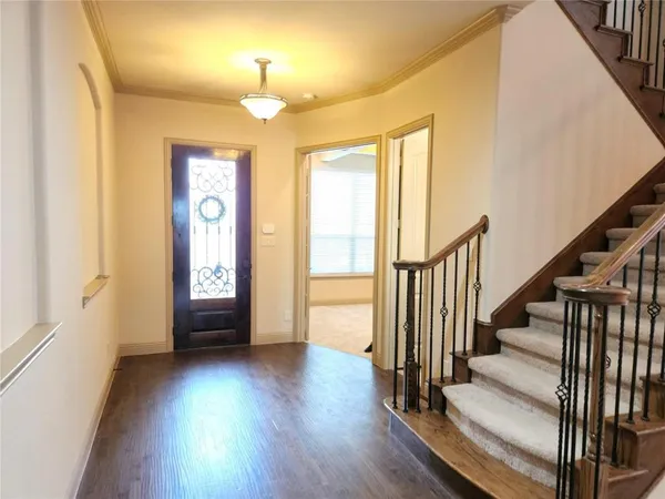 a view of a livingroom with wooden floor and stairs