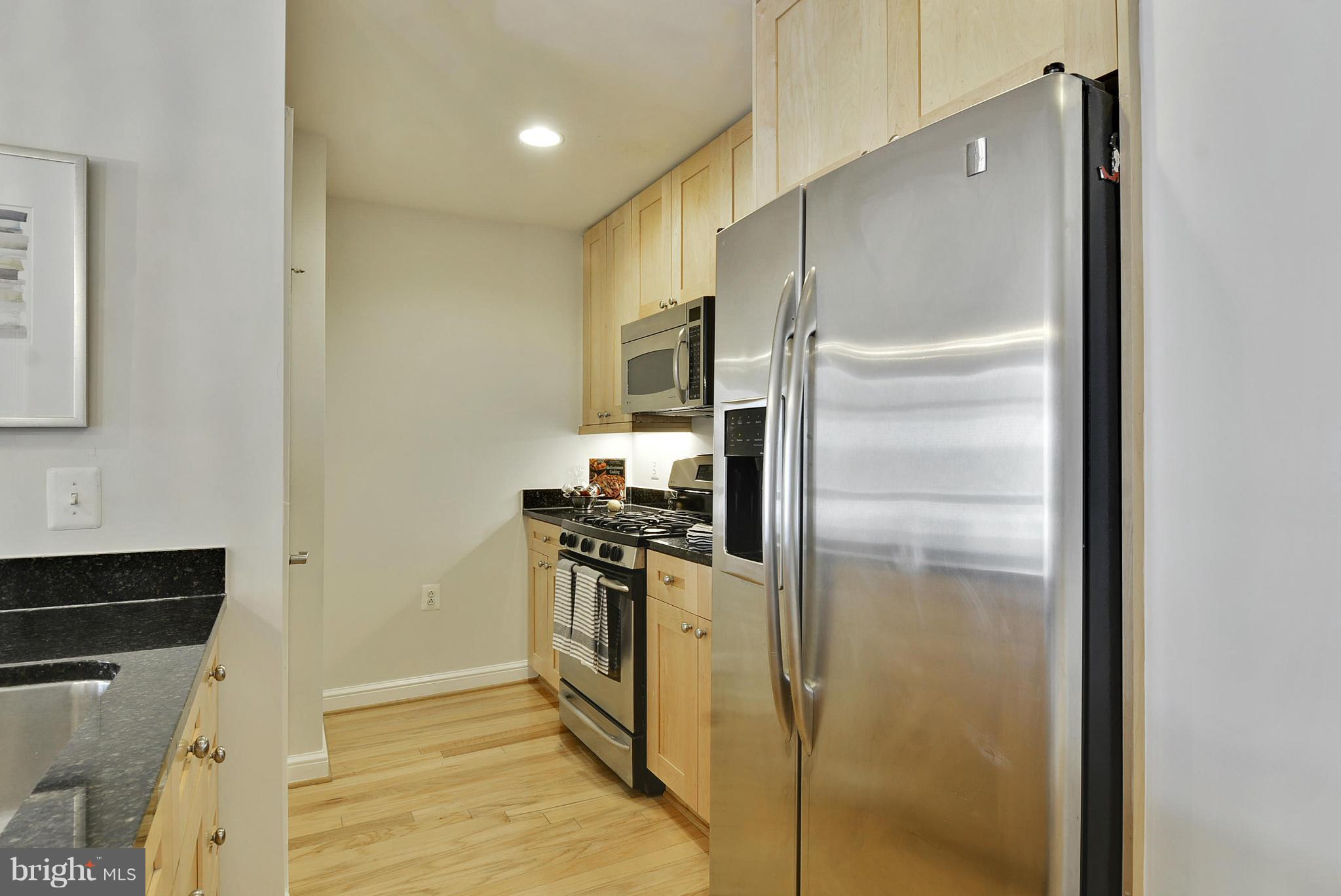 11990 Market Street, Unit 1204 Reston, VA 20190 - Photo 15 of 30 a kitchen with a refrigerator and a sink