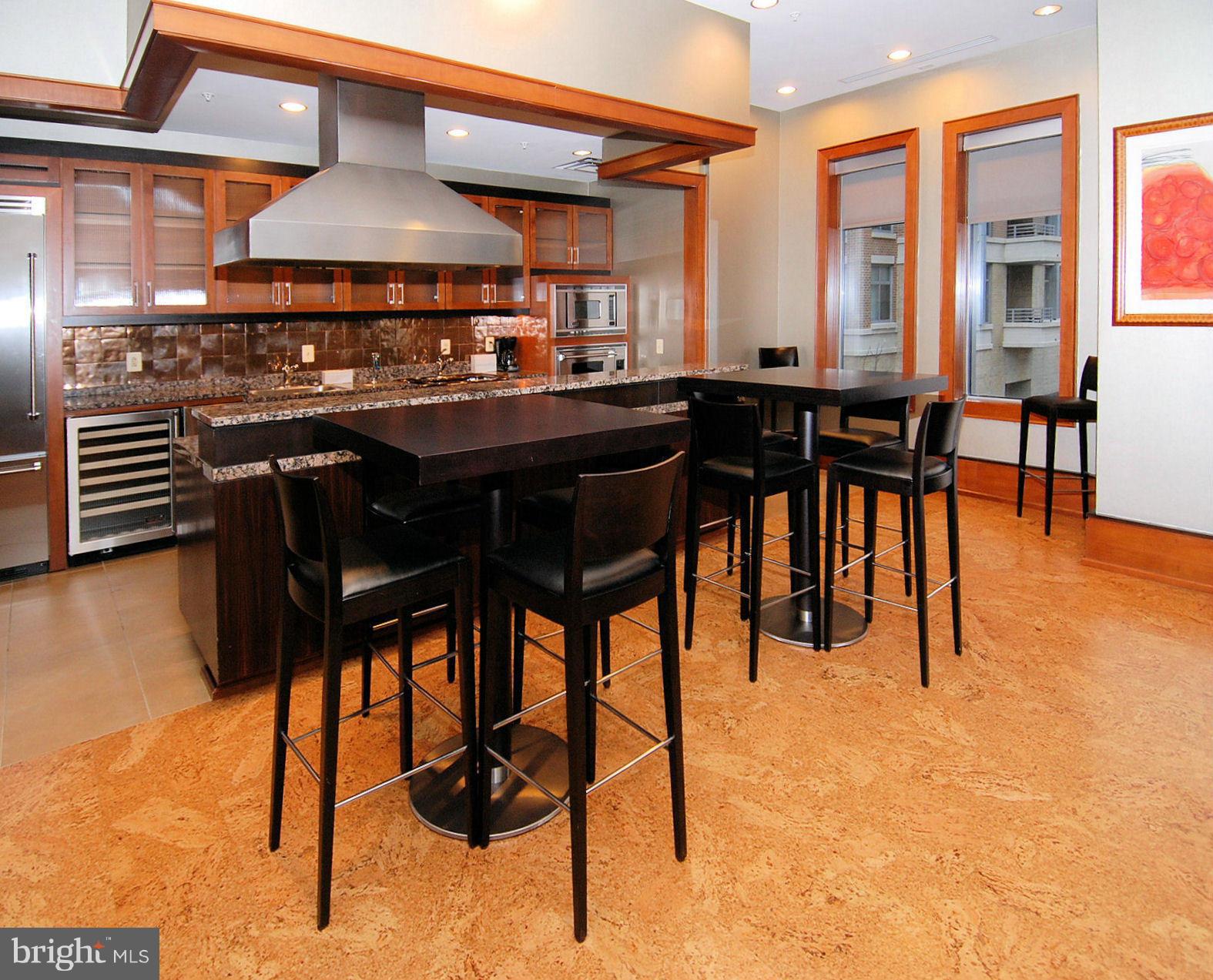 11990 Market Street, Unit 1204 Reston, VA 20190 - Photo 10 of 30 a kitchen with stainless steel appliances kitchen island granite countertop dining table chairs cabinets and a large window