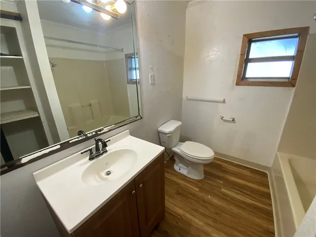 a bathroom with a toilet a sink and mirror