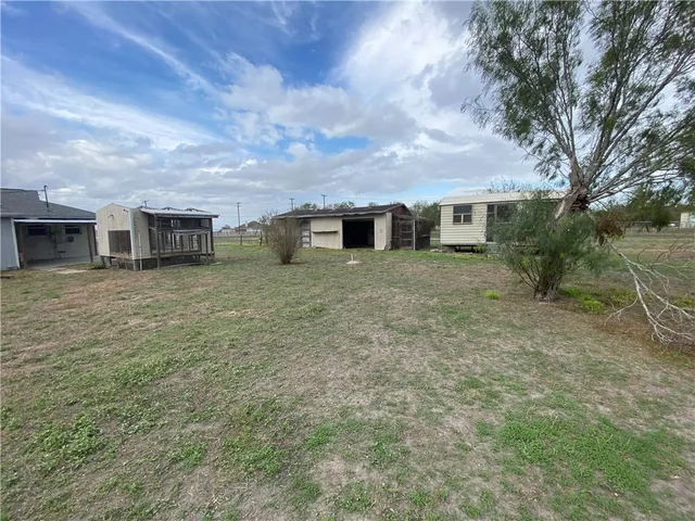 a view of a house with a yard and sitting area