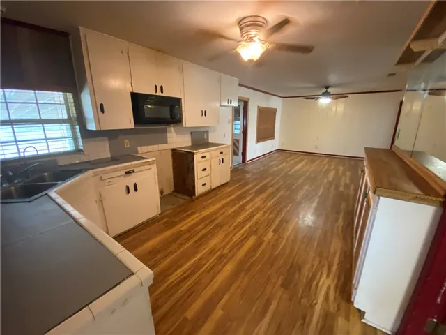 a kitchen with stainless steel appliances granite countertop a sink dishwasher a stove and a microwave oven with cabinets