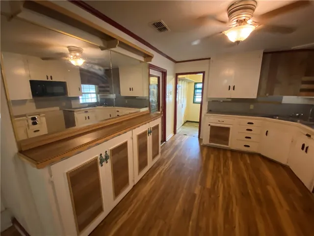 a large kitchen with stainless steel appliances granite countertop a lot of counter space and wooden floor