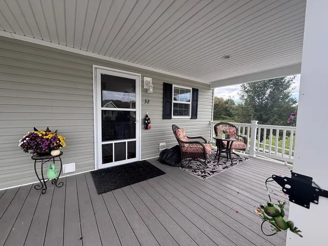 a living room with furniture two window and a potted plant