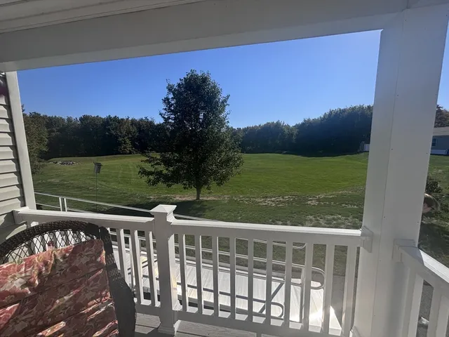 a view of a green field with wooden fence
